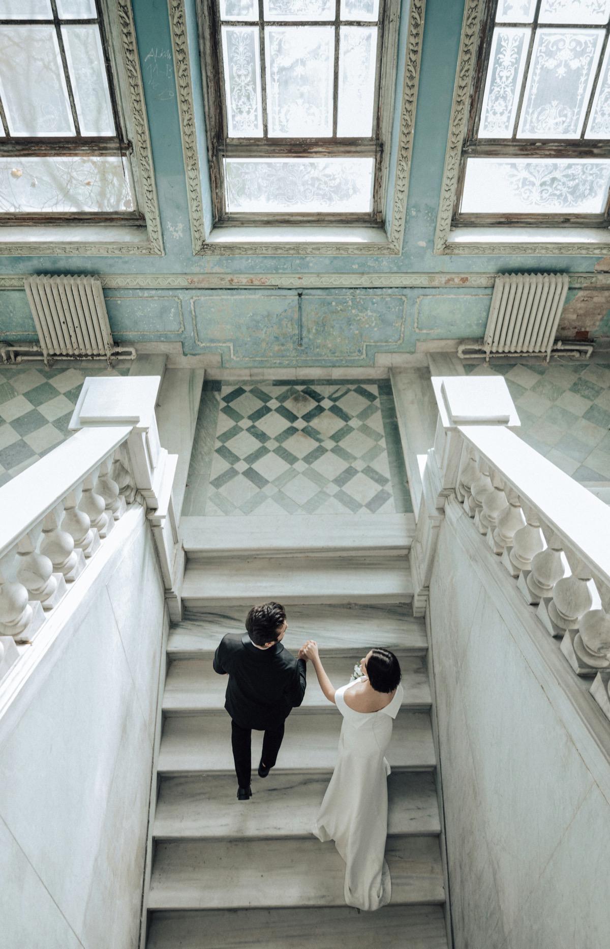 Wedding couple descending grand staircase in Budapest venue
