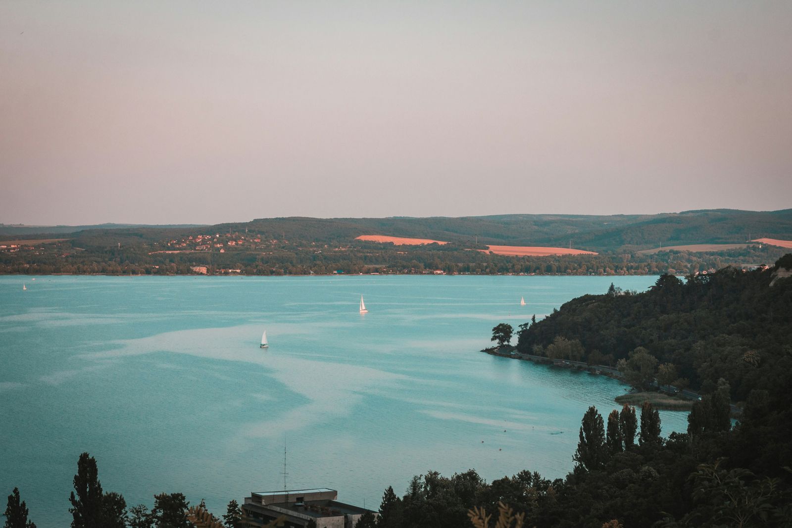 Sailboats on Lake Balaton at dusk seen from the wooded Tihany Peninsula